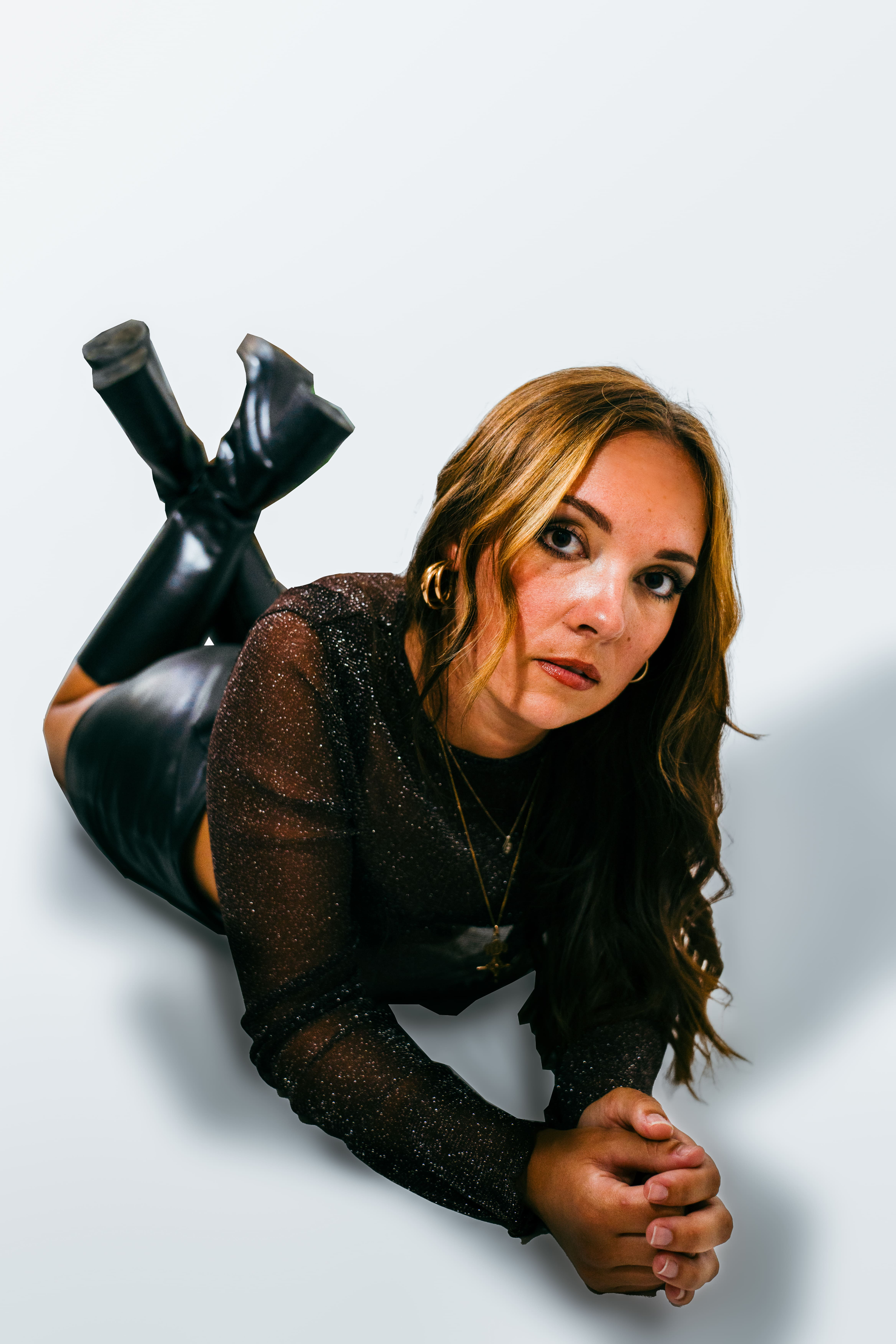 photo femme allongée en studio jambes croisées cheveux longs chatains blonds mannequin t-shirt à paillettes jupe et bottes hautes noires à talons photographge de mode chambéry grenoble