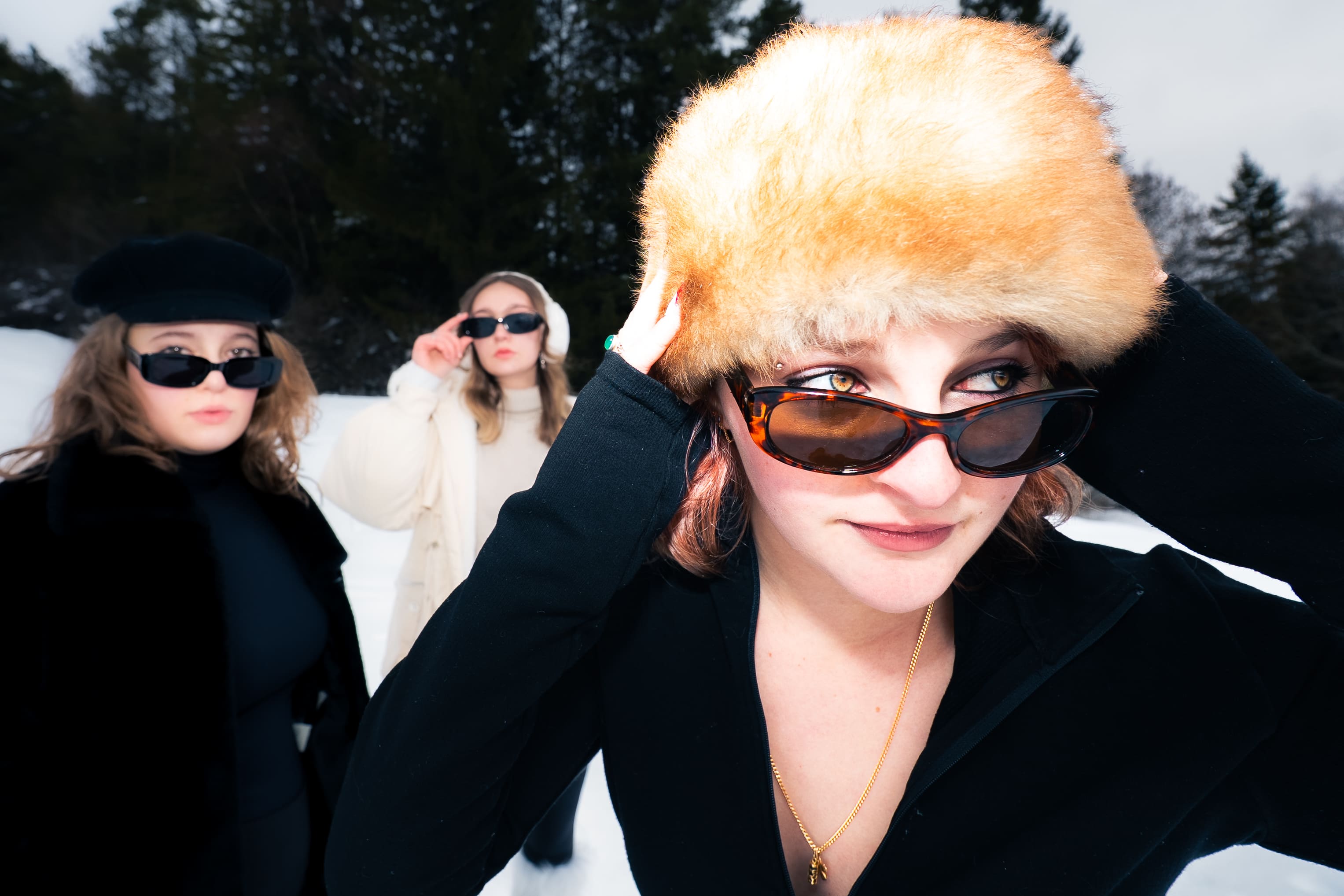 photo mode grande angle tête femme premier plan et deux femmes en arrière plan au flash à la neige style de riche chapka